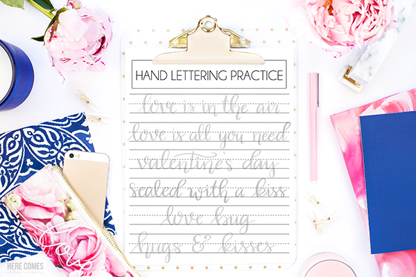 valentines day hand lettering practice sheets on desk